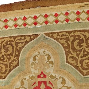 Flatwoven rug detail showing a cartouche pattern in brown, tan, red, and sage green geometric borders.