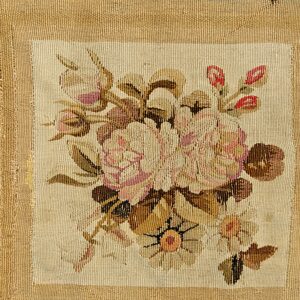 Woven detail displaying a rectangular panel of pink floral pattern surrounded by wide horizontal beige and green stripes.