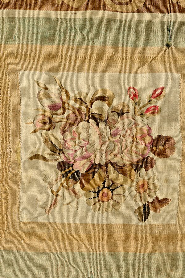 Woven detail displaying a rectangular panel of pink floral pattern surrounded by wide horizontal beige and green stripes.