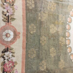 Muted sage rug field with khaki flowers and a cream border featuring detailed pink, blue, and green floral motifs.