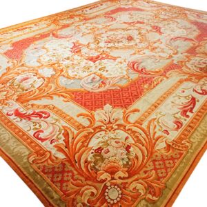 Ornate classical rug in peach, coral, and cream, featuring detailed floral medallions and scrolling borders.