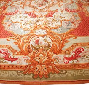 Highly detailed rug displaying complex cartouches and floral bouquets in vibrant orange, red, and cream tones.