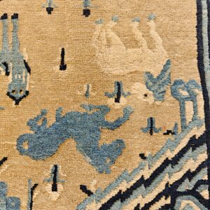 Textured beige rug detail with stylized animal and geometric motifs in light blue and dark navy.