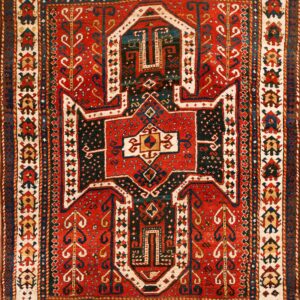 Red and navy tribal rug featuring a central stepped geometric medallion surrounded by patterned cream borders.