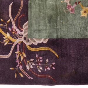 Dark purple border with gold, pink, and taupe floral carving contrasts with a sage green rug field.