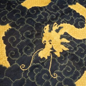 Plush rug detail showing a gold dragon against a dark blue background with scrolling cloud motifs.
