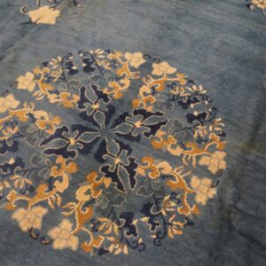 Blue rug with a detailed circular floral pattern in cream, gold, and dark blue.