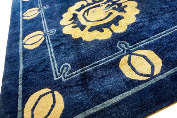 Plush, indigo rug displaying a bold yellow floral motif and light blue decorative bordering.