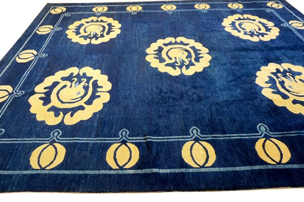 Deep blue rug with contrasting yellow stylized floral medallions and a geometric border pattern.