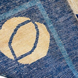 Close-up of the rug reverse showing blue and beige flat weaving next to the high blue pile surface.