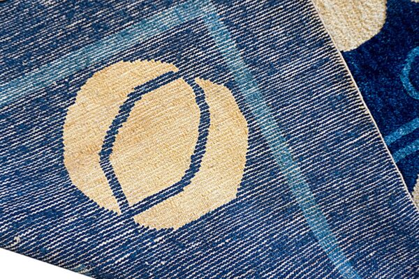 Close-up of the rug reverse showing blue and beige flat weaving next to the high blue pile surface.