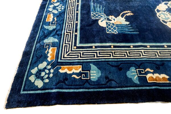 Plush navy blue rug with detailed light blue, cream, and tan oriental borders and central bird pattern.