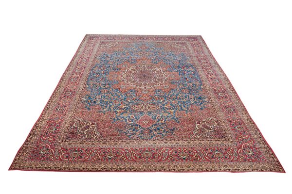 Large rectangular rug featuring a detailed traditional floral medallion pattern in red and blue.