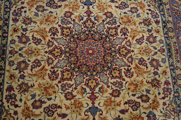 Low-pile rug with a cream field and dense navy, red, light blue, and orange traditional floral designs.