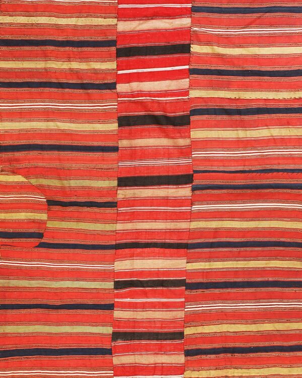 Three vertical panels form a flatweave rug patterned with dense horizontal stripes in red, tan, and black.