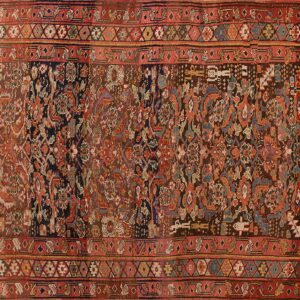 Traditional rectangular rug featuring detailed floral and geometric motifs in faded rust, brown, and dark blue tones.