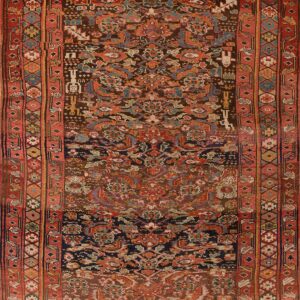 Dark brown rug with intricate geometric and stylized patterns, featuring multiple borders in shades of red and rust.