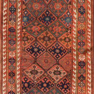 Rust and navy geometric runner rug with a repeating diamond field and multi-layered medallion borders.