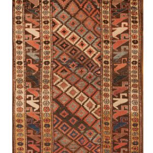 Dark runner rug with a geometric diamond field and stylized bird figures in rust and blue borders.