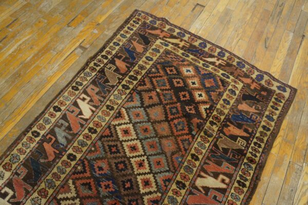 Geometric rug featuring dark brown, blue, and rust colors with stylized figures on distressed wood planks.