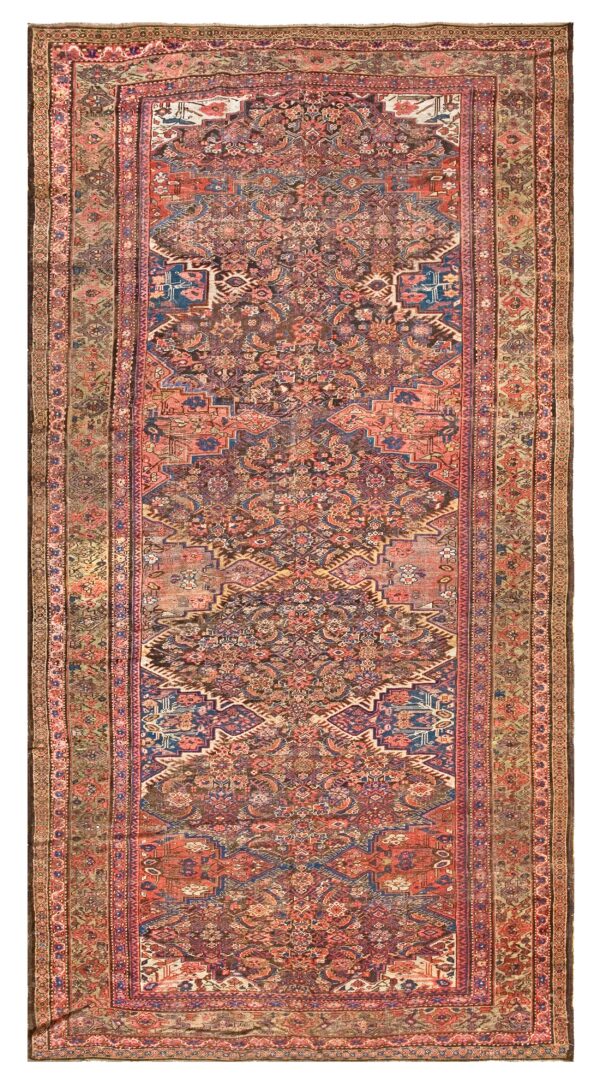 Narrow runner rug featuring a detailed traditional pattern in muted coral, navy blue, brown, and sage.