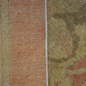 Khaki and brown patterned texture contrasts with a faded salmon vertical stripe section along a finished white seam.