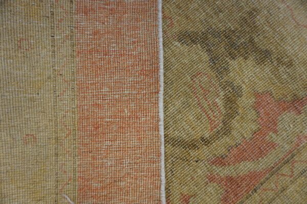 Khaki and brown patterned texture contrasts with a faded salmon vertical stripe section along a finished white seam.