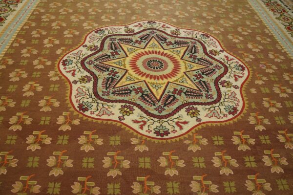 Brown rug featuring a vibrant, multicolored eight-pointed star medallion and stylized floral field patterns.
