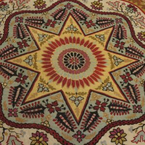Flatweave rug detail with a central yellow and red eight-pointed star medallion surrounded by multicolored floral motifs.