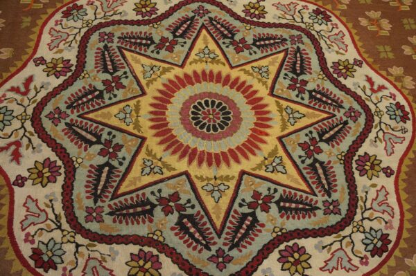 Flatweave rug detail with a central yellow and red eight-pointed star medallion surrounded by multicolored floral motifs.