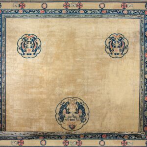 Tan field rug with complex blue and red borders and three large central stylized medallions.