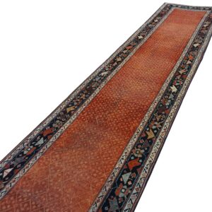 Low pile runner rug featuring a rusty orange central field and dark geometric patterned borders.
