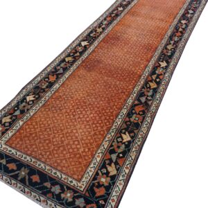 Rust orange runner with a faint diamond pattern and detailed dark navy geometric borders.