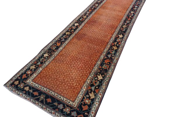 Rust orange runner with a faint diamond pattern and detailed dark navy geometric borders.