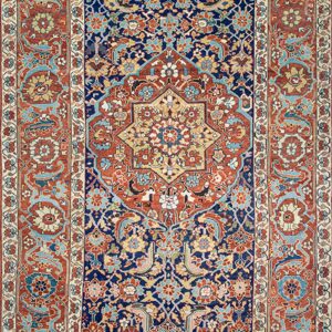 Ornate traditional rug featuring a navy blue field, a central medallion, and complex red, gold, and light blue motifs.