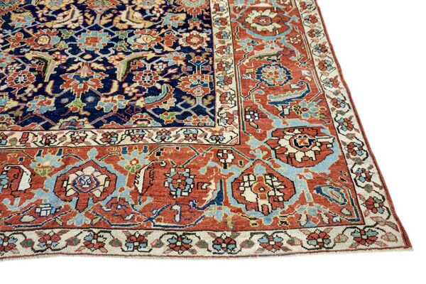Intricate traditional rug pattern featuring a navy field and wide rust border with light blue motifs.