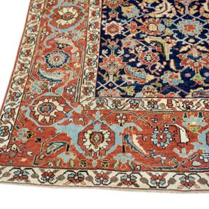 Navy blue and terracotta rug corner showing intricate traditional floral and vine patterns with low pile.