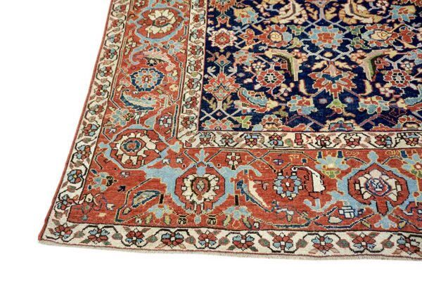 Navy blue and terracotta rug corner showing intricate traditional floral and vine patterns with low pile.