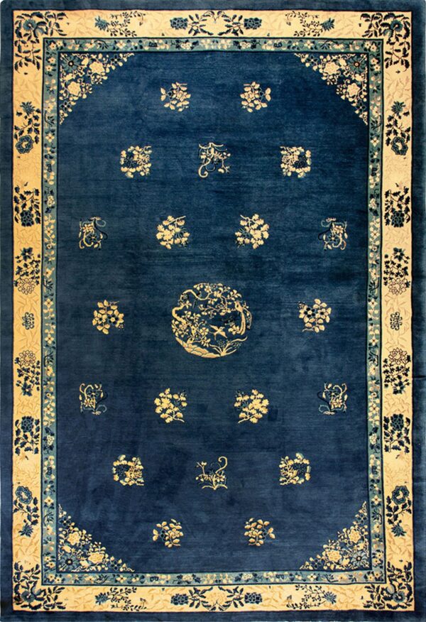 Traditional dark blue rug with a wide tan border and scattered yellow and light blue floral designs.