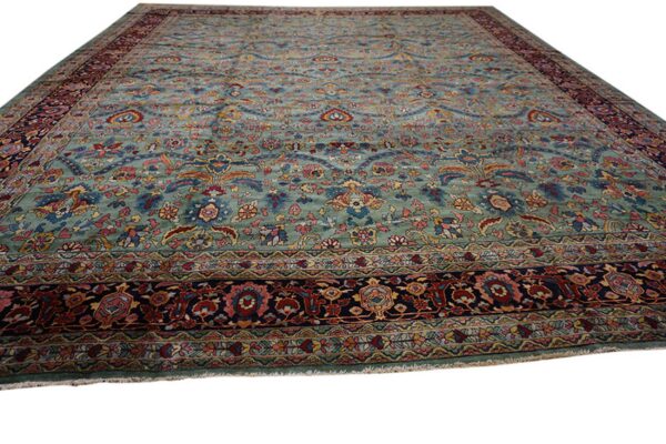 Ornate floral rug with a teal blue-green field and multi-colored navy and maroon borders.