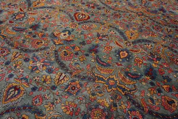 Muted seafoam rug featuring traditional scrolling floral and paisley patterns in coral, blue, and gold.