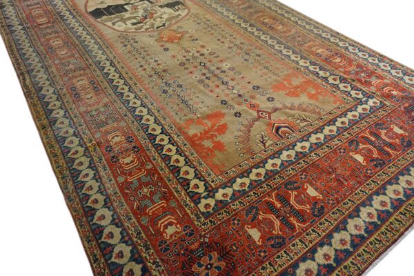 Tan central field rug with wide complex red and blue geometric borders and a central figural medallion.