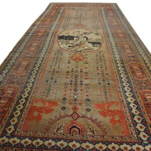Narrow tan runner rug featuring a central pastoral medallion bordered by complex red and blue designs.