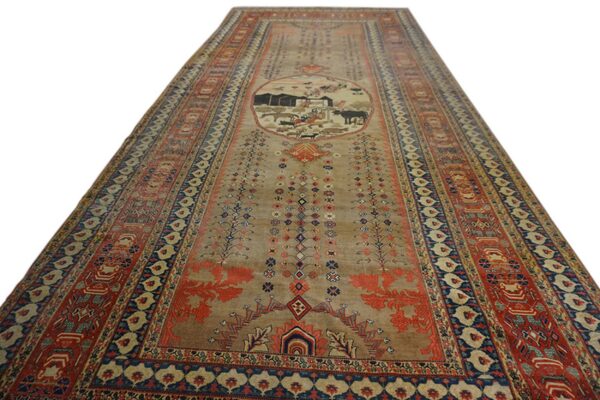 Narrow tan runner rug featuring a central pastoral medallion bordered by complex red and blue designs.
