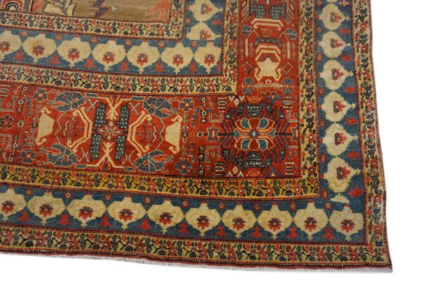 Intricate rug border detail showing red, blue, and gold geometric patterns and stylized floral motifs.