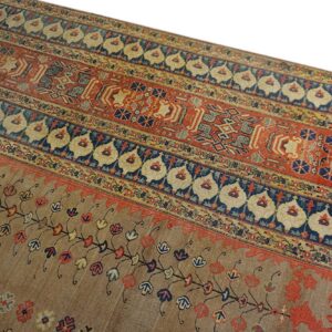 A rug detail showing wide red, blue, and tan horizontal bands with intricate geometric and floral designs.