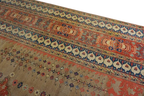 A rug detail showing wide red, blue, and tan horizontal bands with intricate geometric and floral designs.