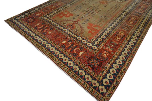 A traditional rug featuring a beige field and wide red and blue patterned borders.