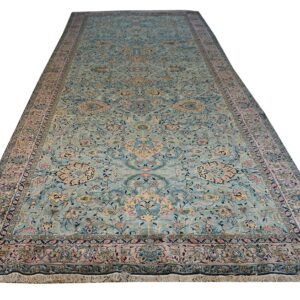 Long runner rug featuring an elaborate traditional pattern in soft blue, pink, and gold tones.