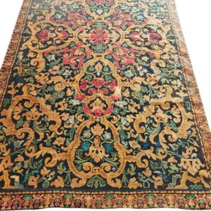 Low-pile rug with dark ground, golden Baroque scrolling patterns, and bright red and green floral accents.